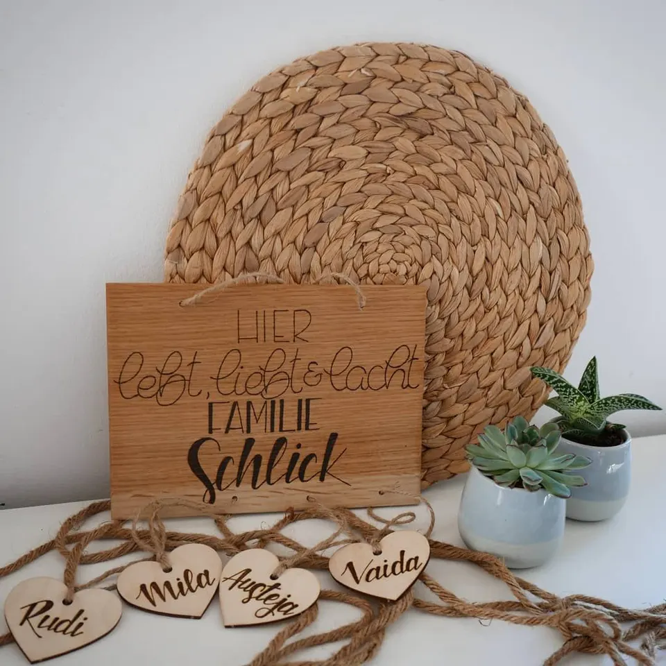 Holzschild Hier lebt, liebt und lacht Familie Schlick mit vier Herzen