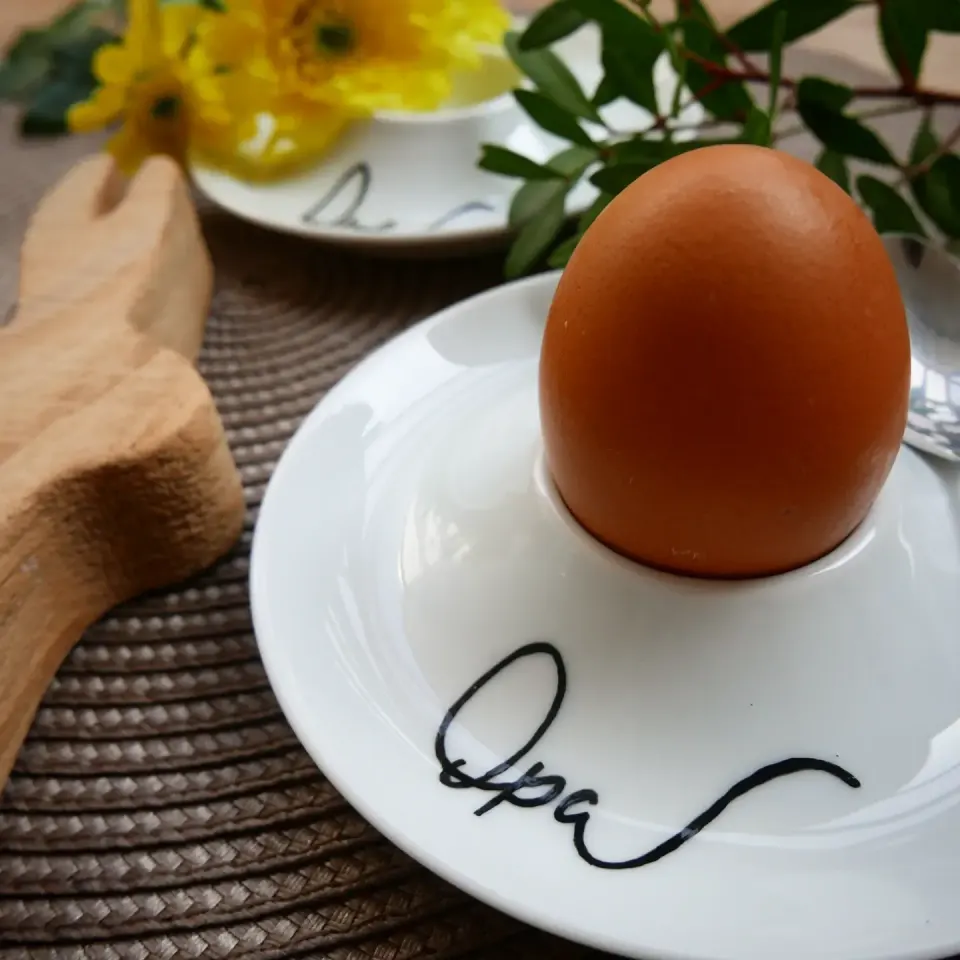 Weißer Eierbecher mit Ei und dem Schriftzug Opa