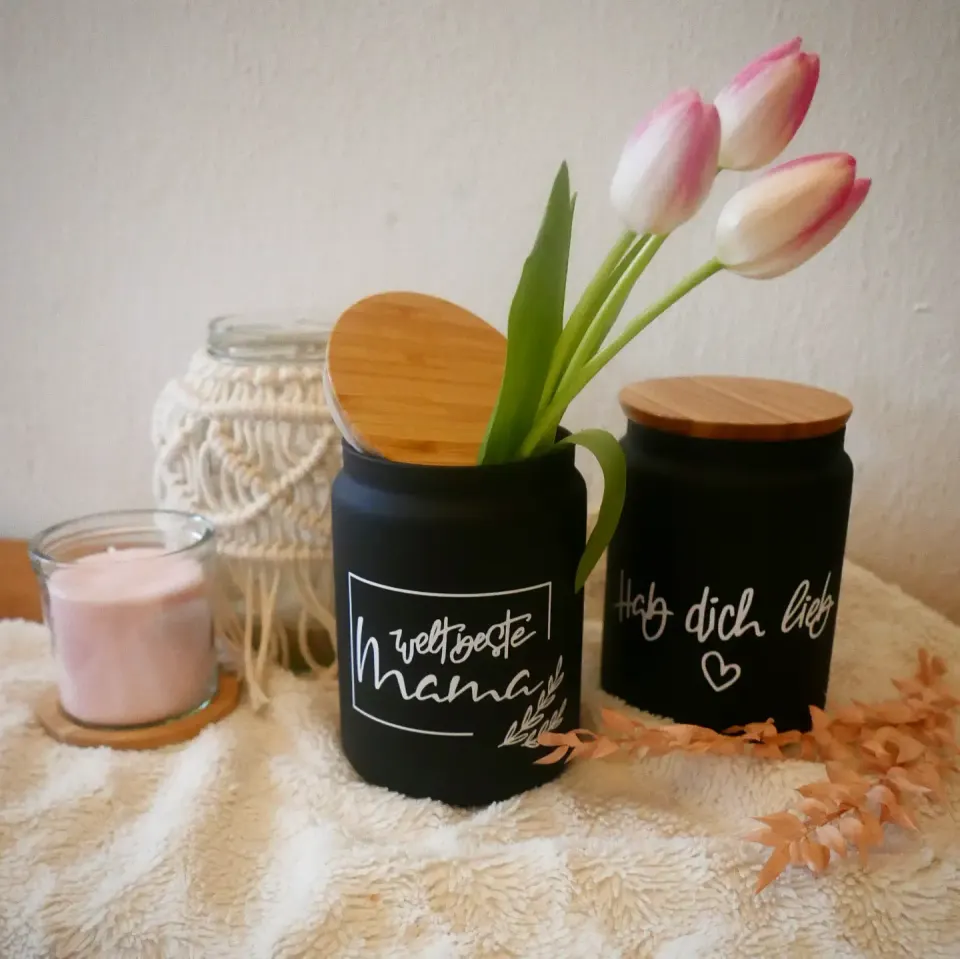 Zwei schwarze Vorratsgläser mit Holzdeckel und weißer Schrift