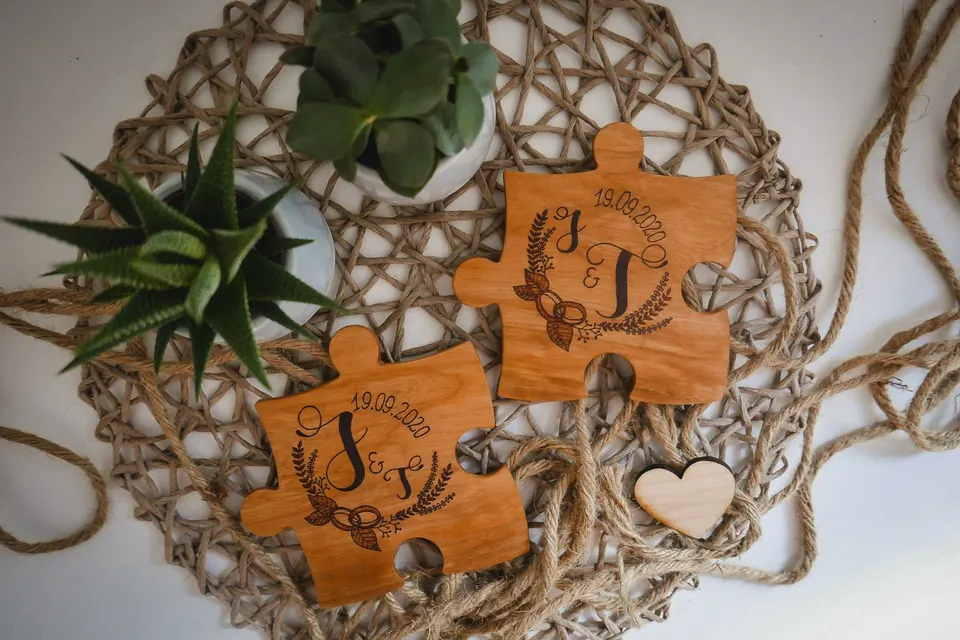 Zwei Puzzleteile aus Holz mit Initialen, Kranz und Hochzeitsdatum