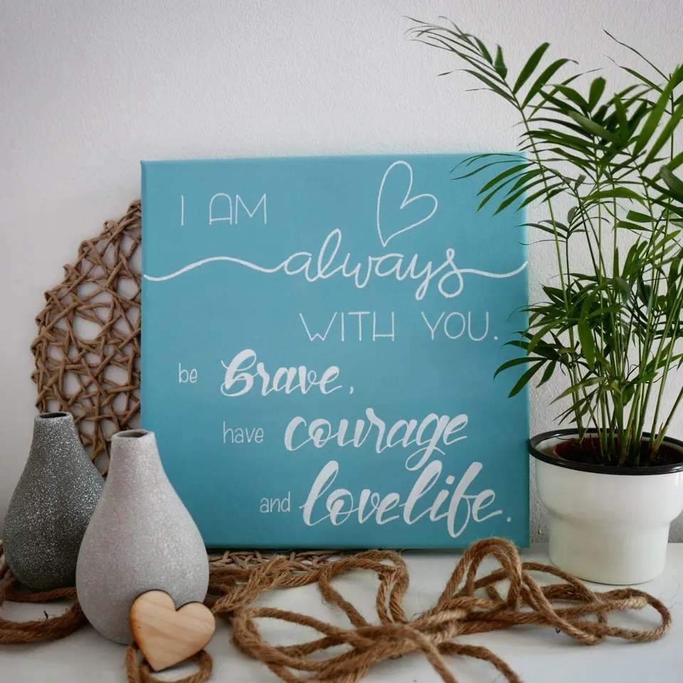 Türkise Leinwand mit einem englischen Spruch in weißer Schrift