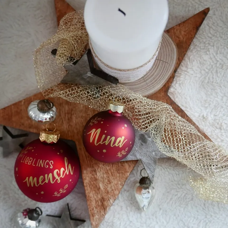 Rote Christbaumkugeln mit Nina und Lieblingsmensch auf einem Holzstern