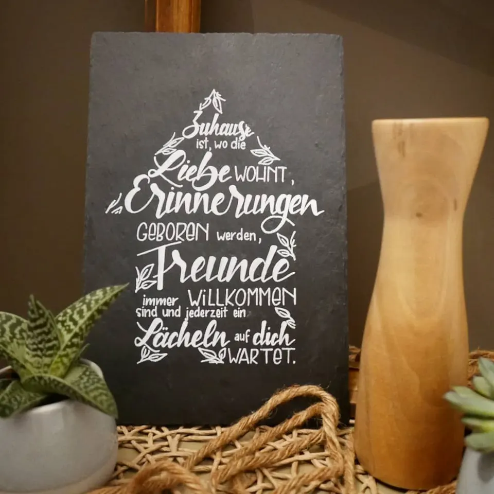 Schiefertafel mit einem Spruch über das Zuhause in Form eines Tannenbaums