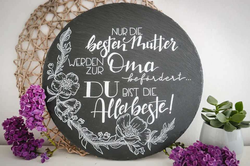 Runde Schieferplatte mit Spruch für die Oma, umrahmt von gezeichneten Blumen