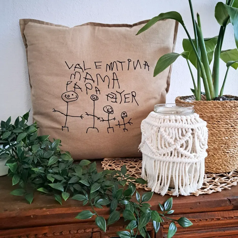 Beiger Polster mit einer Kinderzeichnung von Valentina, Mama und Papa
