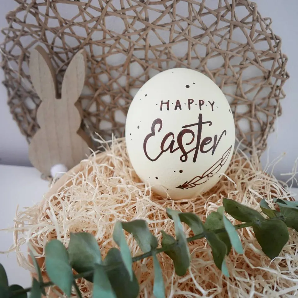Weißes Ei mit Happy Easter in schwarzer Schrift
