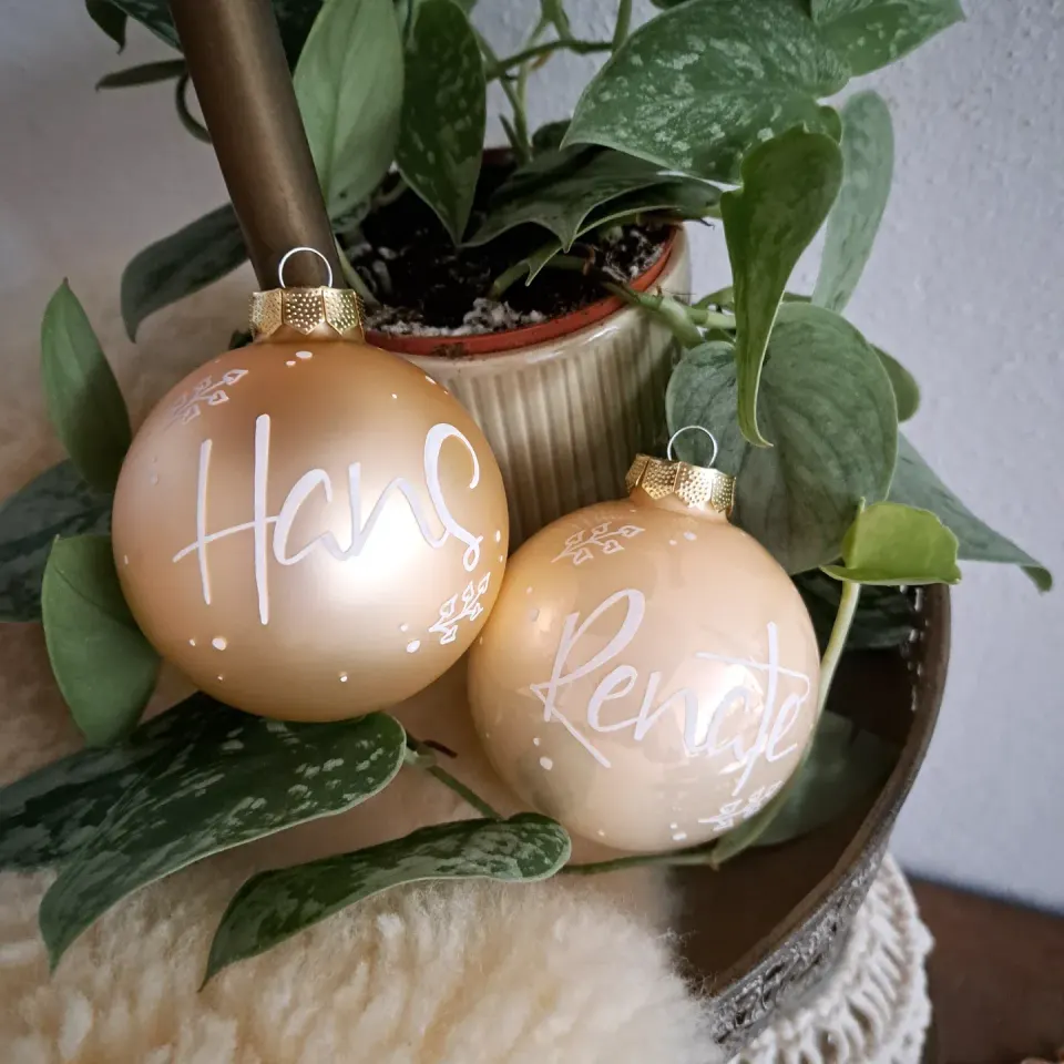 Zwei goldene Christbaumkugeln mit Hans und Renate